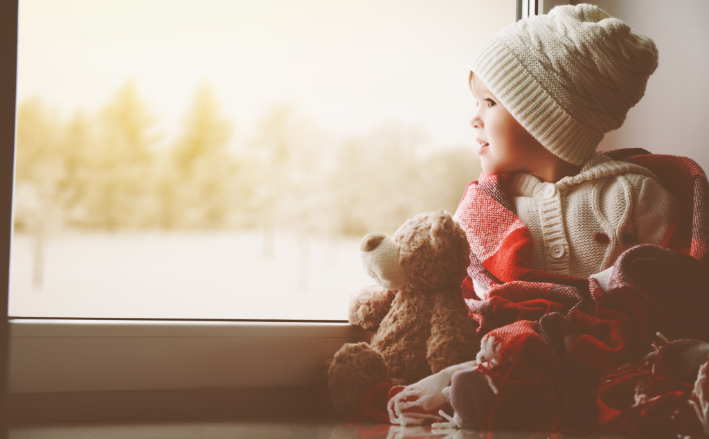child little girl with teddy bear at window